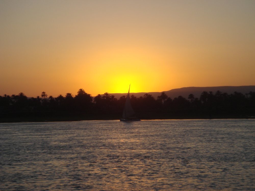 A felucca on the Nile at sunset, the river that still connects every stop between Cairo and Luxor.